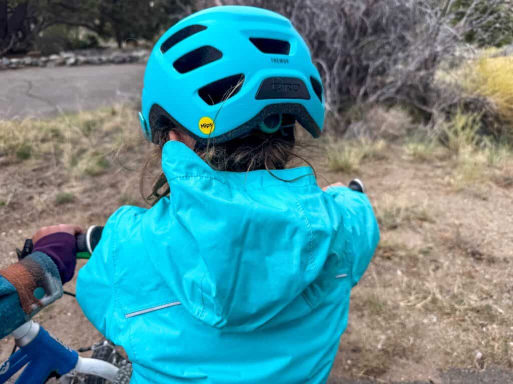 Child wearing teal Giro Tremor MIPS helmet on bike