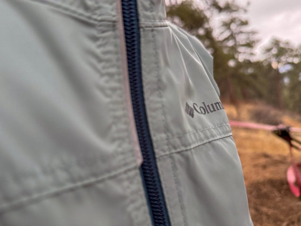 Close-up of gray Columbia jacket with navy zipper outdoors