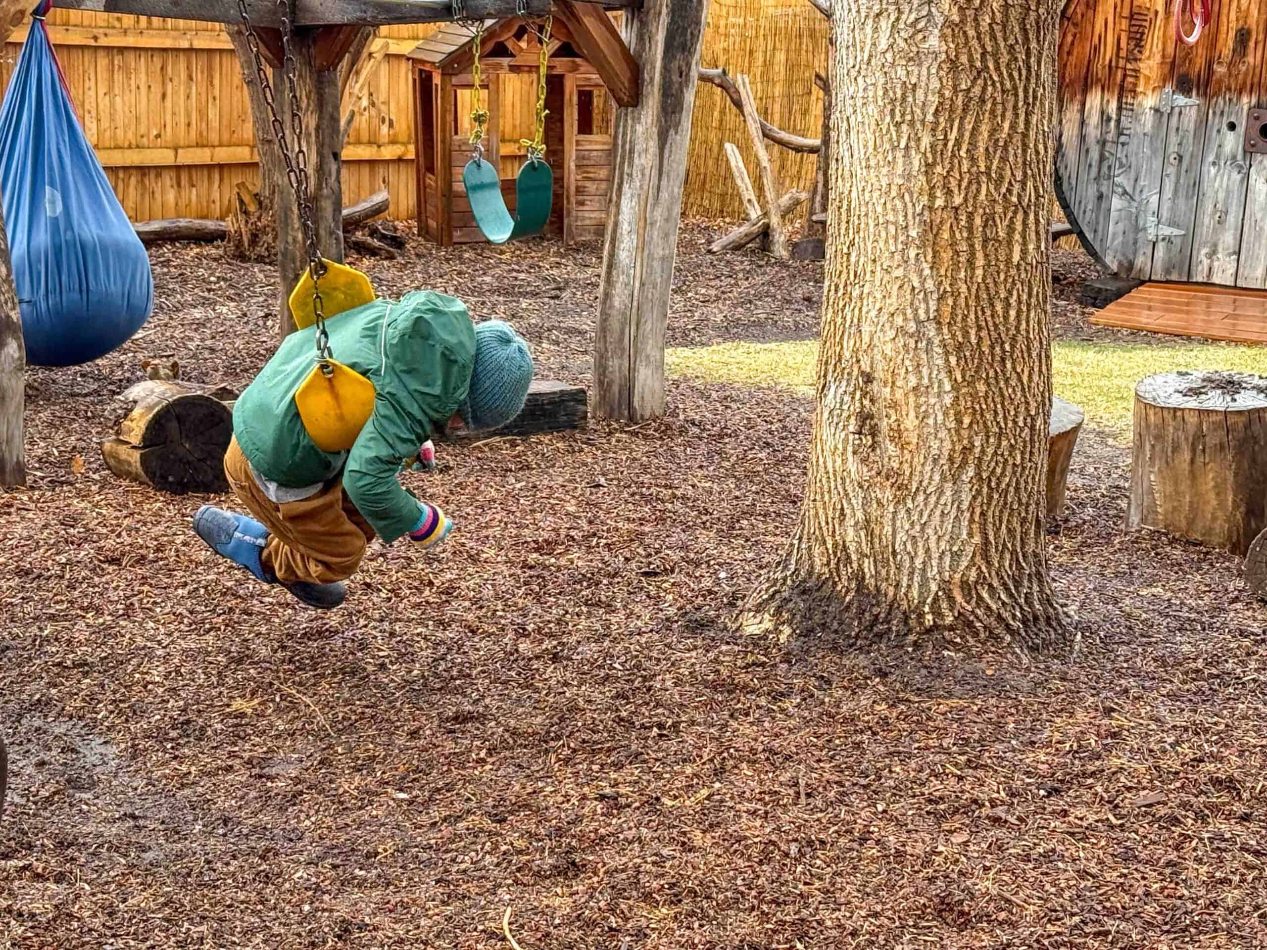 boy playing on swing in park