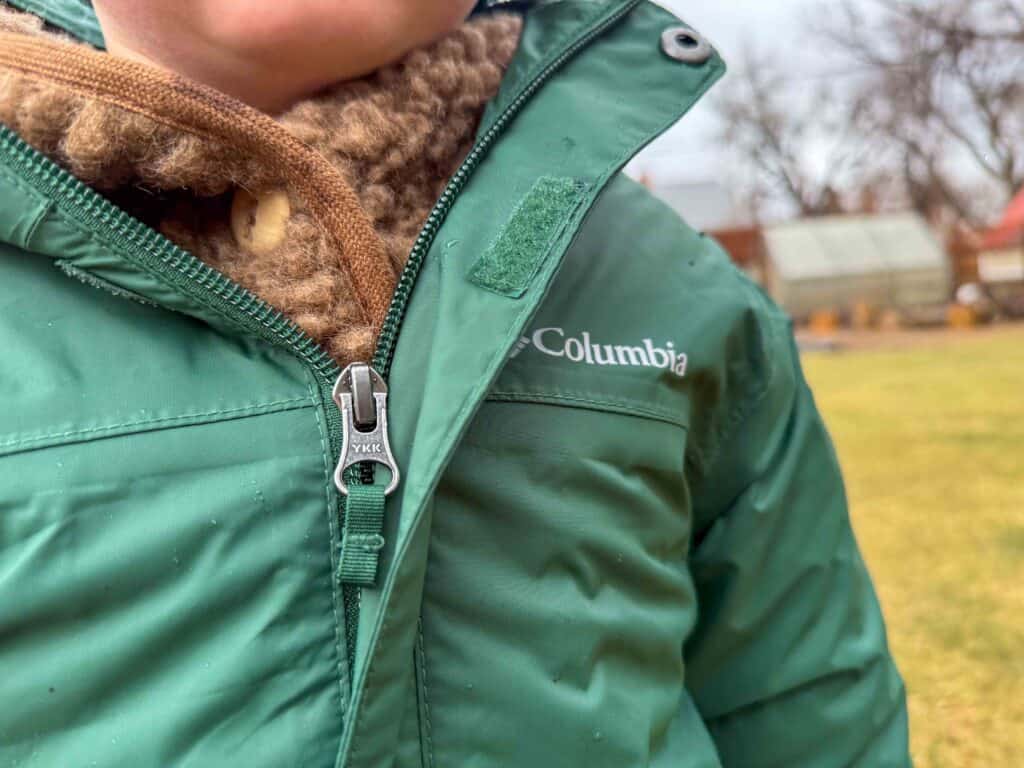 Child wearing green Columbia winter jacket outdoors