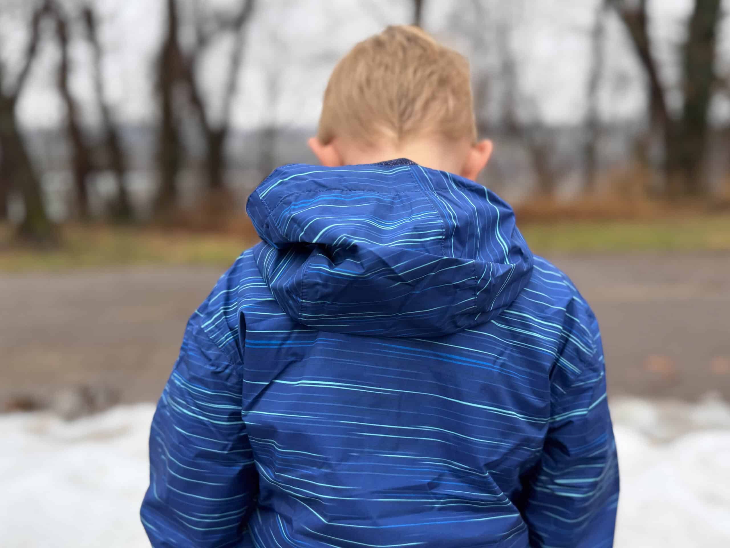 Young boy in blue striped winter jacket outdoors
