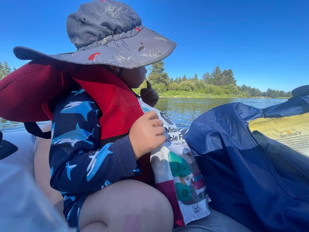 Young child snacking on a kayak river trip