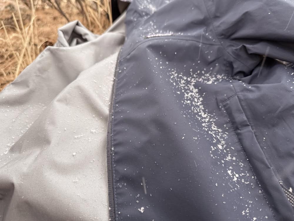 Snow-dusted gray outdoor jacket in winter field
