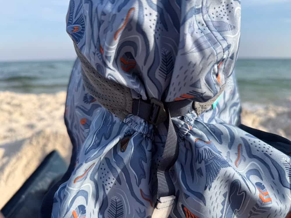 Child wearing patterned sun hat at sandy beach