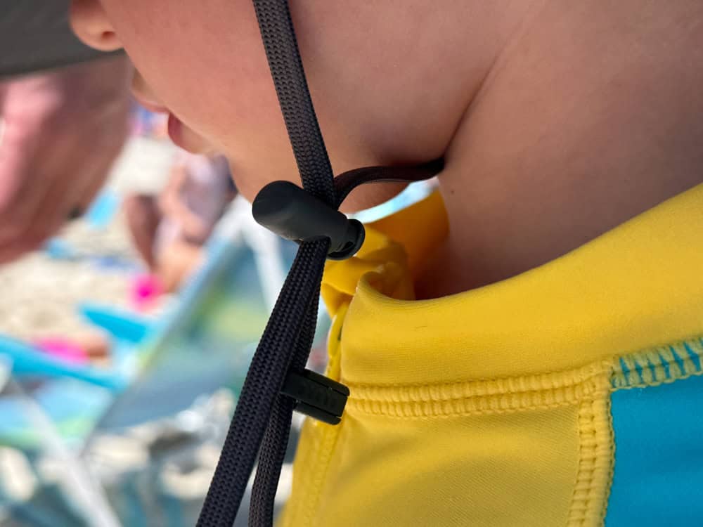 Close-up of child wearing yellow swimsuit with hat strap