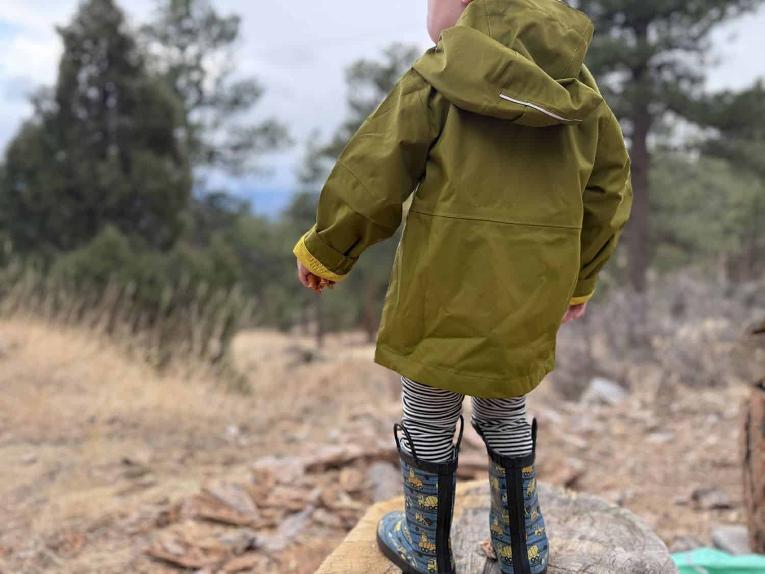 Low angle full length front view of toddler in Columbia Hikebound II Rain Jacket showing overall fit and zipper