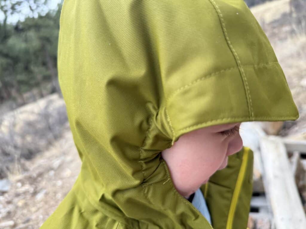 Profile view of toddler wearing Columbia Hikebound II Rain Jacket showing hood fit around face