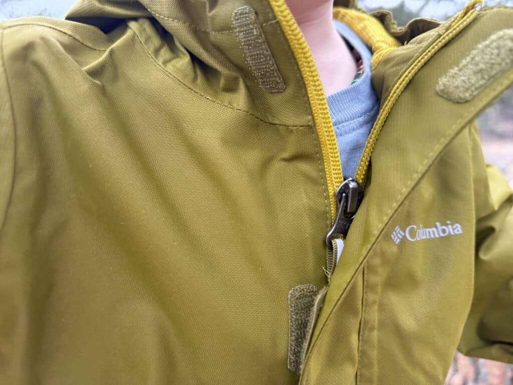 Close-up of Columbia Hikebound II Rain Jacket showing front zipper storm flap with Velcro closure and Columbia logo