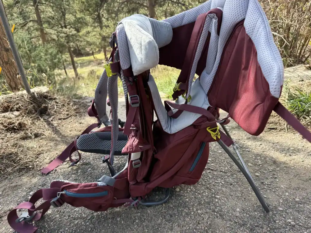 Deuter Kid Comfort child carrier standing on its kickstand on a gravel trail
