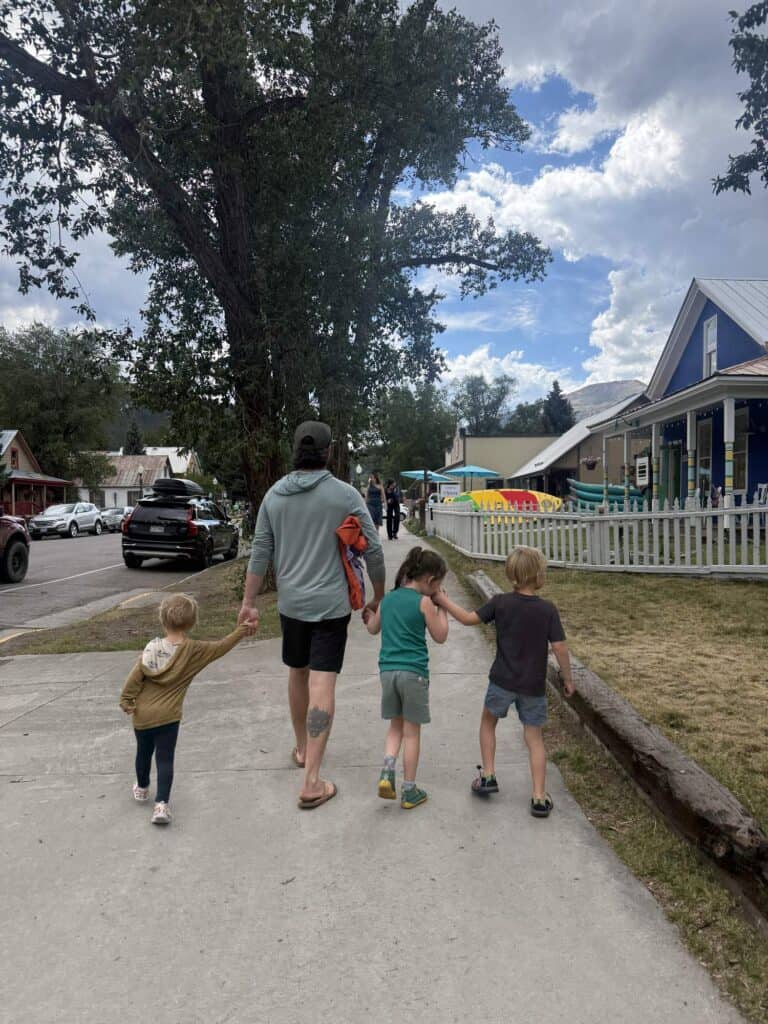 Family walking down a sidewalk in Crested Butte, Colorado, a kid in KEEN Newport H2 sandals