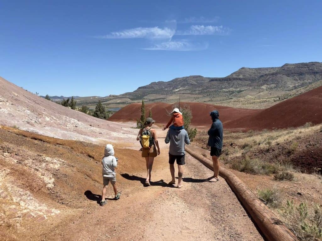 Family hiking the red clay trail at Painted Hills, Oregon, a kid in KEEN Newport H2 sandals