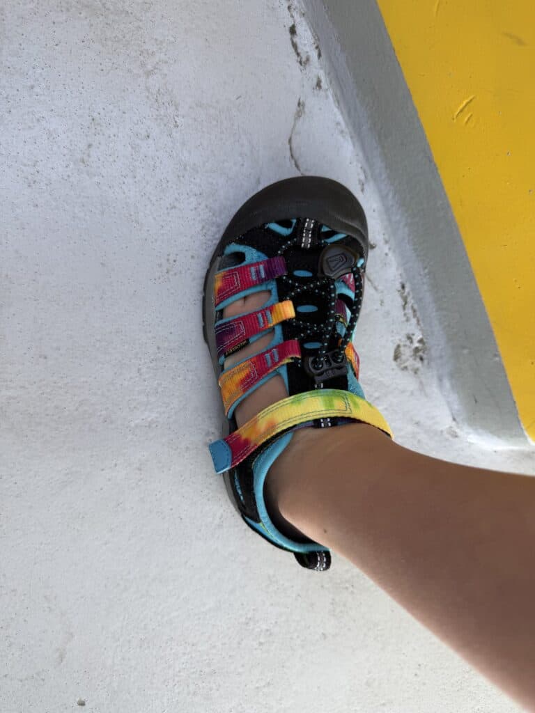 Top-down view of a KEEN Newport H2 kids sandal on a water slide