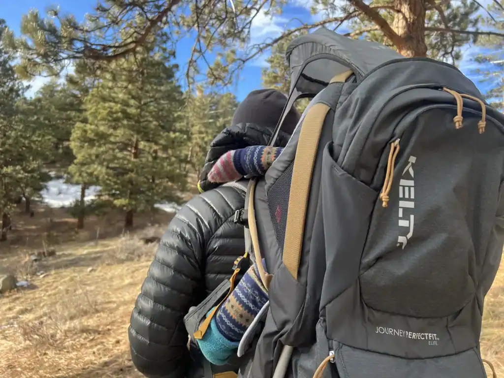 Side view of a toddler riding in the Kelty Journey PerfectFIT Elite child carrier