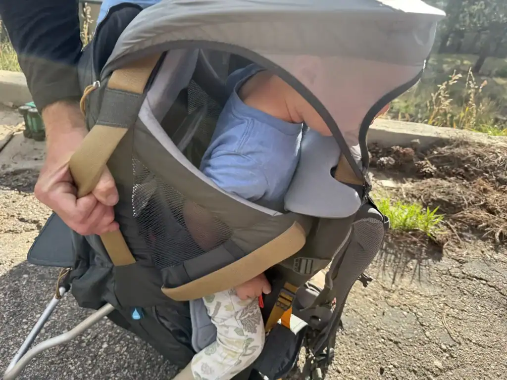 Toddler riding under the sunshade of the Kelty Journey PerfectFIT Elite child carrier