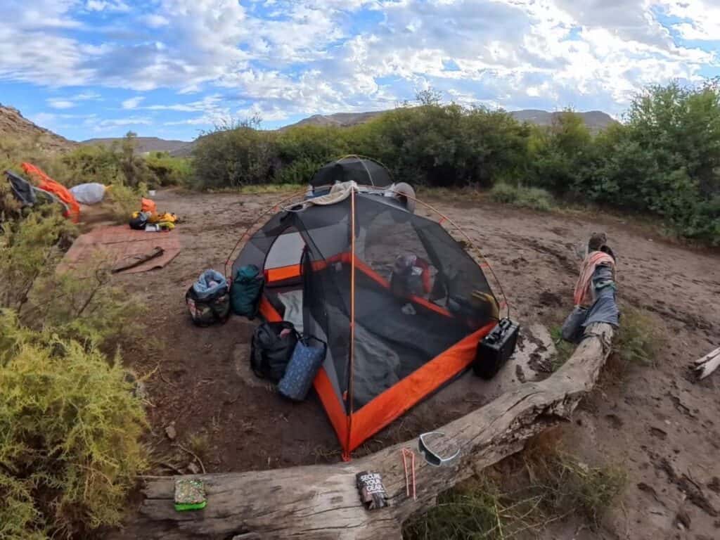 Marmot Tungsten tent body without the rainfly beside a log with gear around it