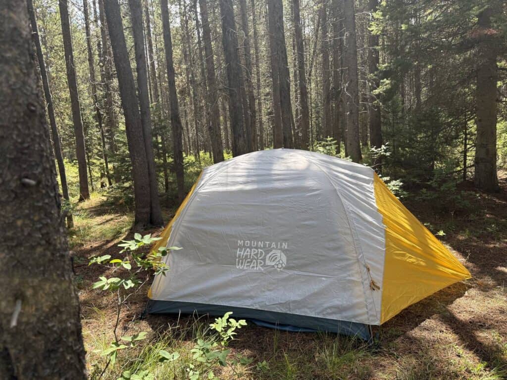 Side view of the Mountain Hardwear Mineral King 3 with its rainfly pitched in a pine forest