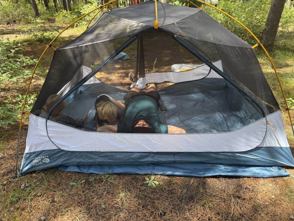 Adult and two children lying inside the mesh tent body of the Mountain Hardwear Mineral King 3