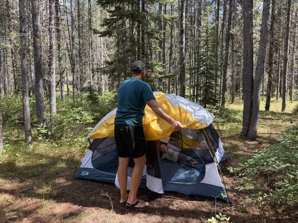 Adult pulling the yellow and white rainfly over the Mountain Hardwear Mineral King 3