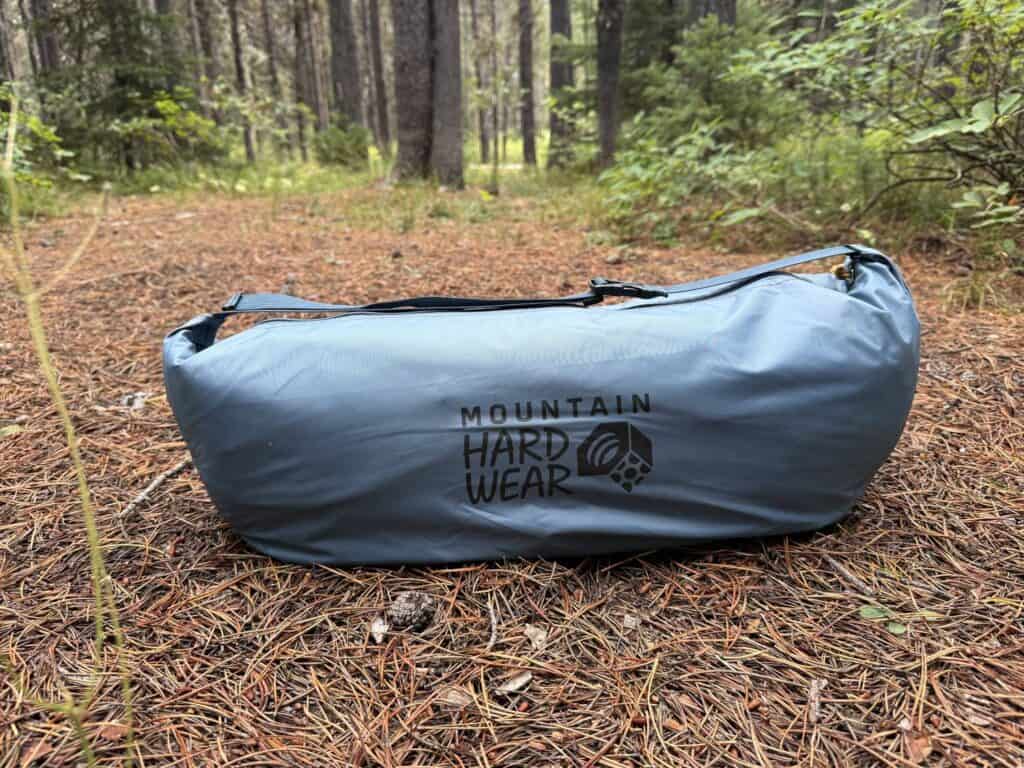 Mountain Hardwear Mineral King 3 packed in its blue stuff sack on a forest floor