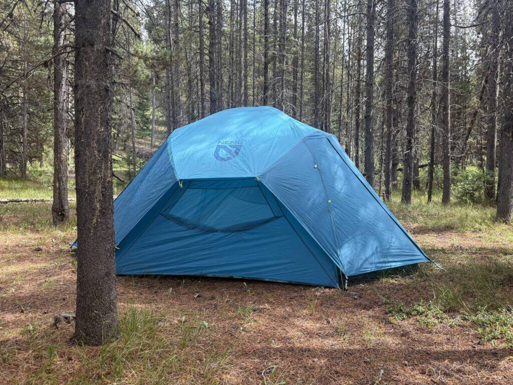NEMO Aurora Highrise 6 with its full blue rainfly pitched in a pine forest