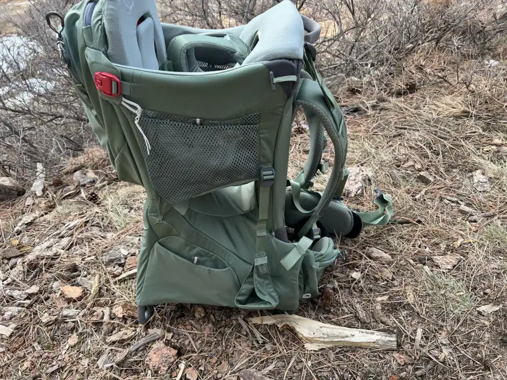 Osprey Poco Premium child carrier standing on its kickstand on a dry hillside