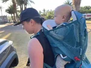 Adult walking in San Ignacio, Baja California Sur, with a baby in the Osprey Poco SLT child carrier