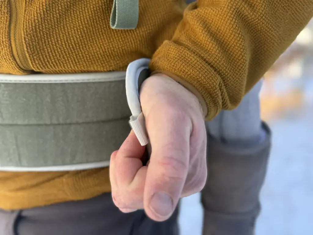 Adult adjusting the wide padded hip belt on the Osprey Poco Soft child carrier