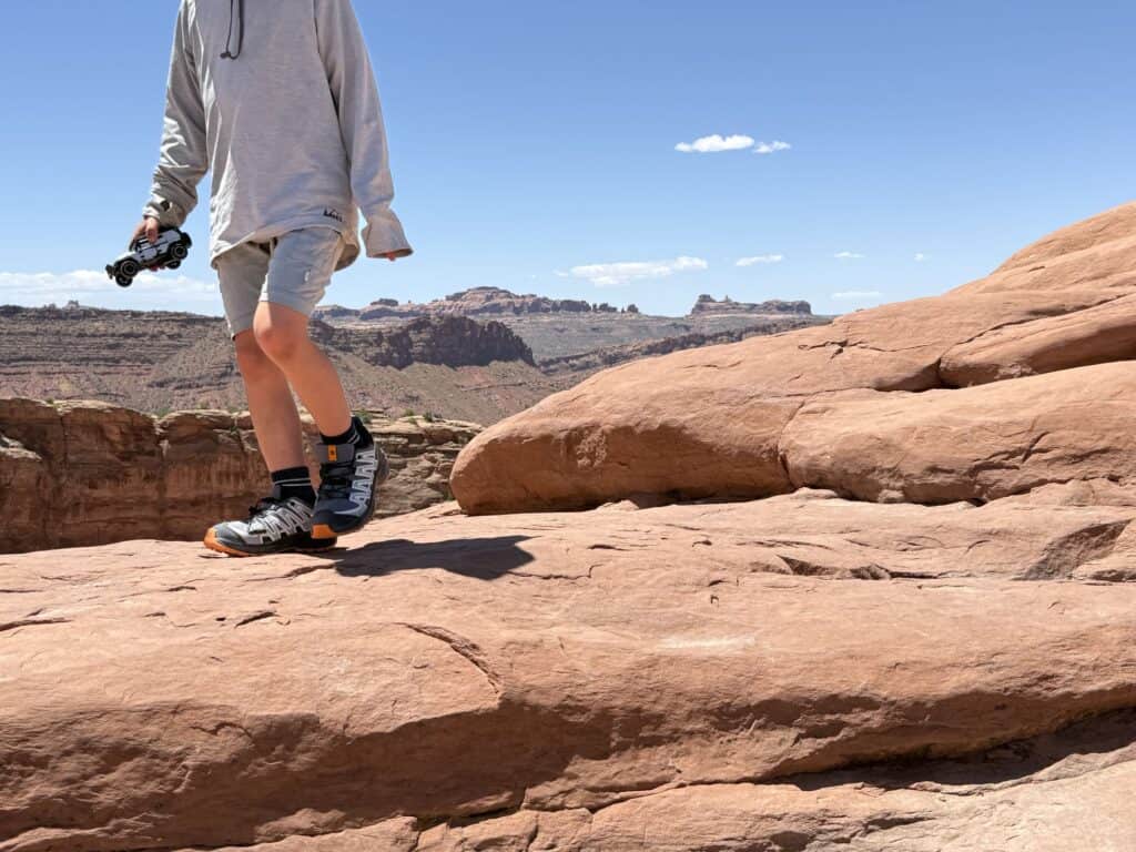 Kid walking across slickrock in Arches National Park in Salomon XA Pro V8 Waterproof shoes