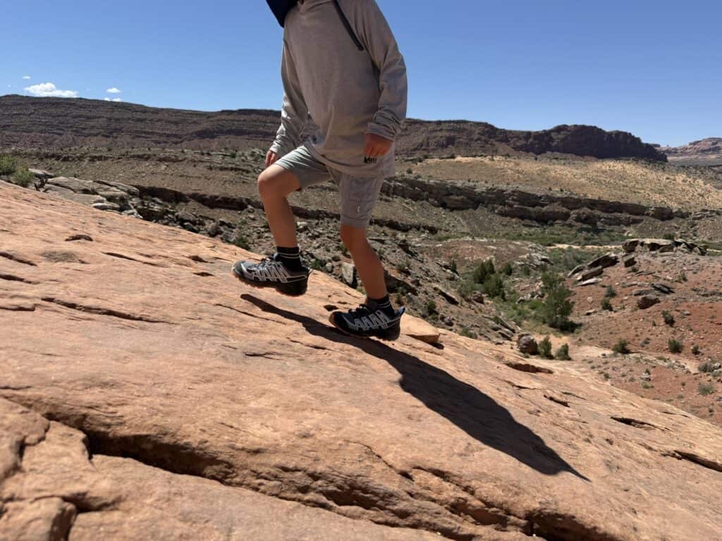 Kid stepping up a slickrock slope in Arches National Park in Salomon XA Pro V8 Waterproof shoes