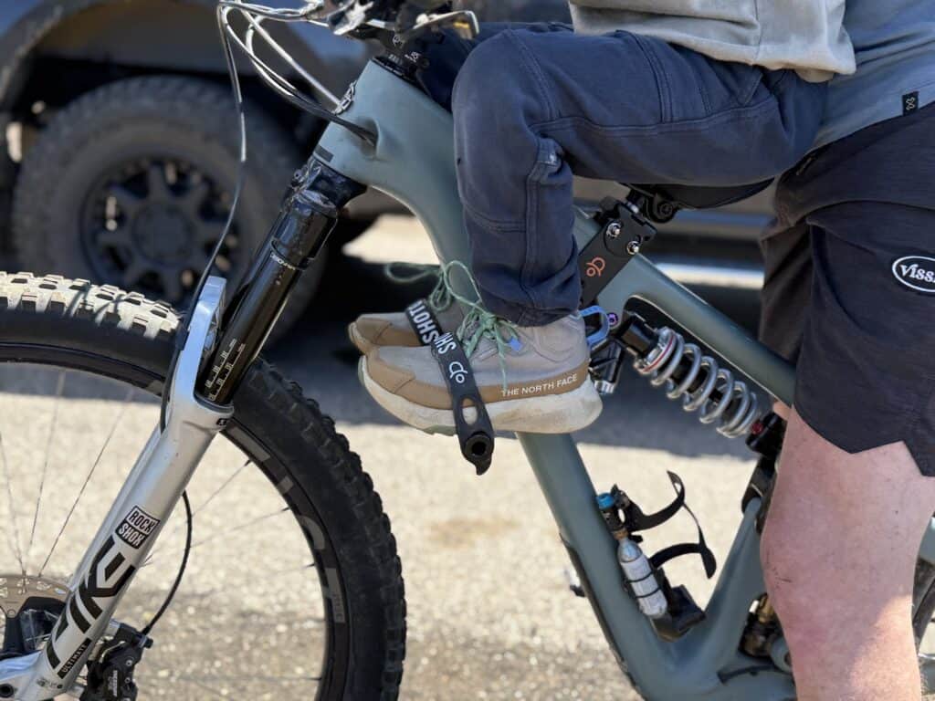Kid riding on a mountain bike front seat wearing The North Face Fastpack II Mid Waterproof boots