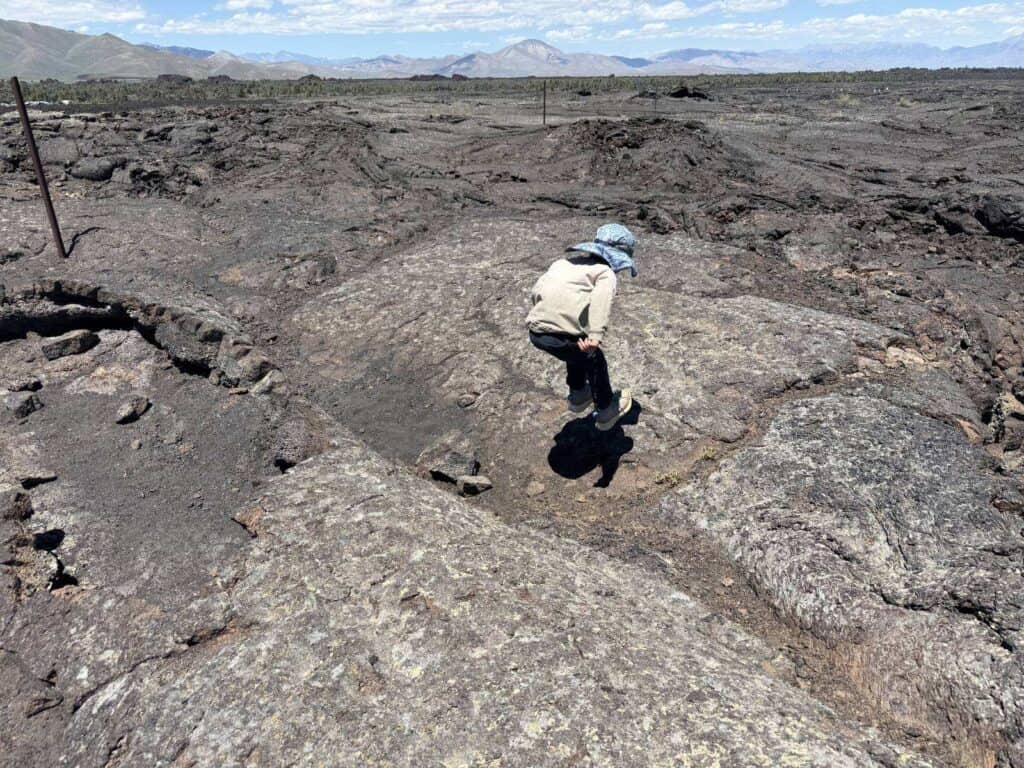 Kid stepping across lava rock at Craters of the Moon, Idaho in The North Face Fastpack II Mid Waterproof boots
